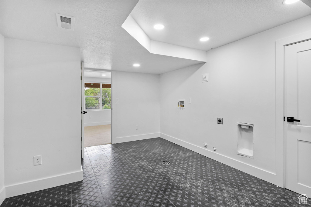 Empty room with a textured ceiling, visible vents, baseboards, and recessed lighting