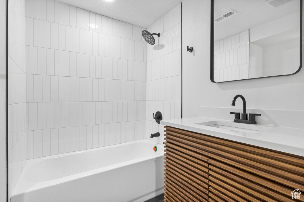 Bathroom with vanity, shower / tub combination, and visible vents