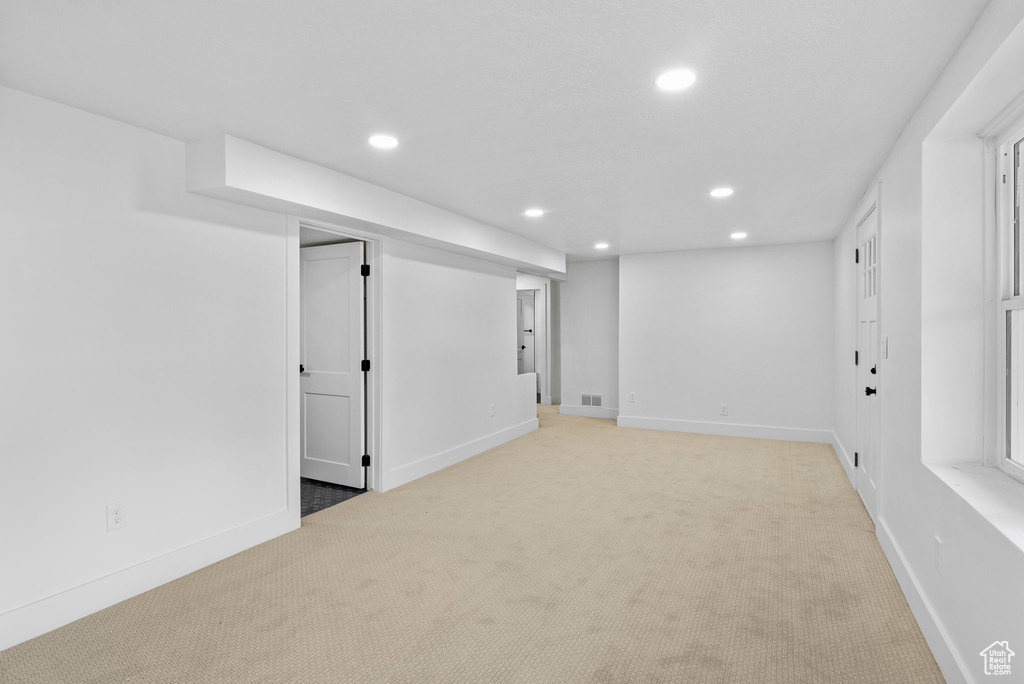 Finished basement featuring baseboards, visible vents, recessed lighting, and light colored carpet