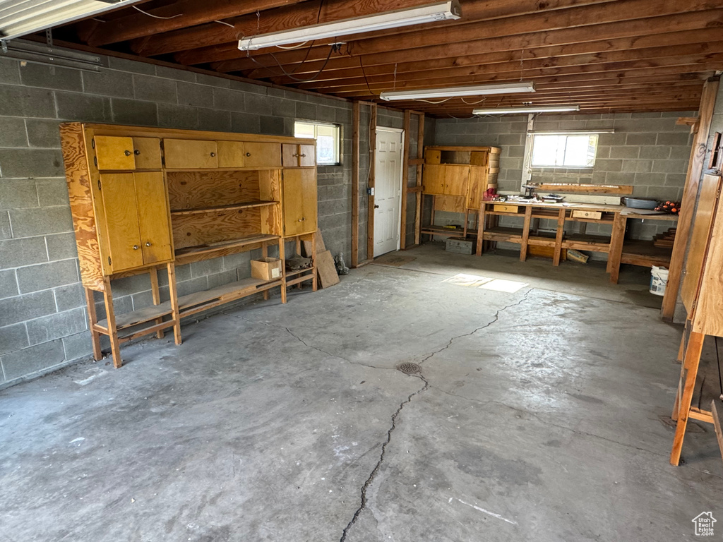Basement featuring a workshop area and concrete block wall