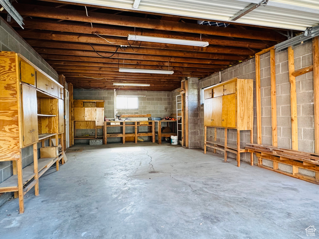 Misc room featuring a workshop area, concrete floors, and concrete block wall