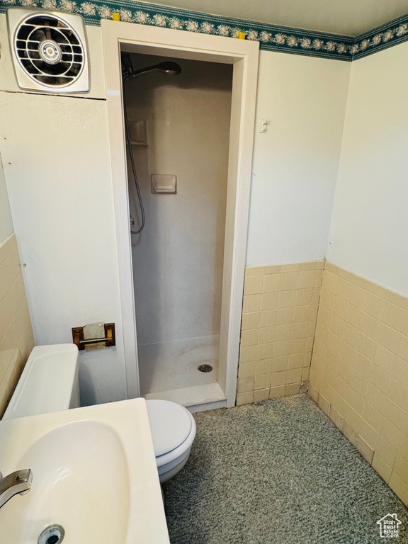 Full bath with a shower stall, toilet, and a sink