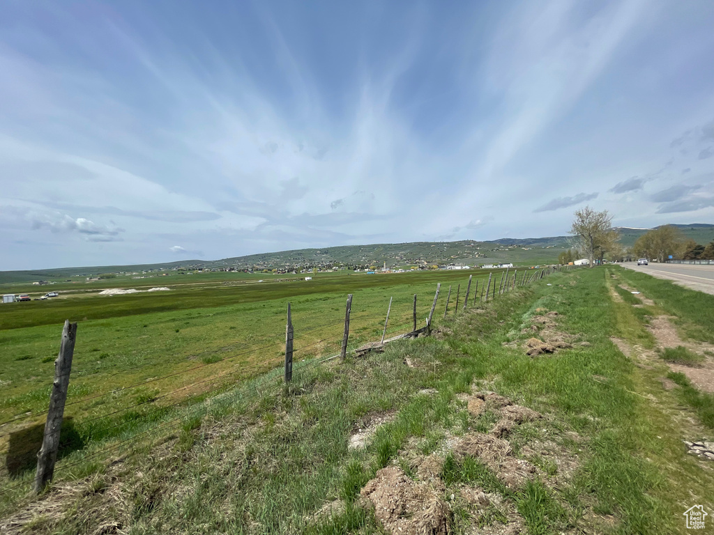 View of yard featuring a rural view and fence