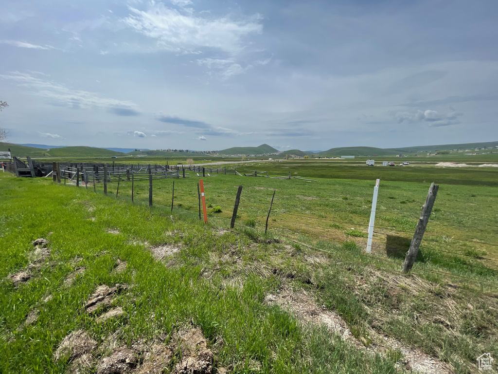 View of yard with a rural view and fence