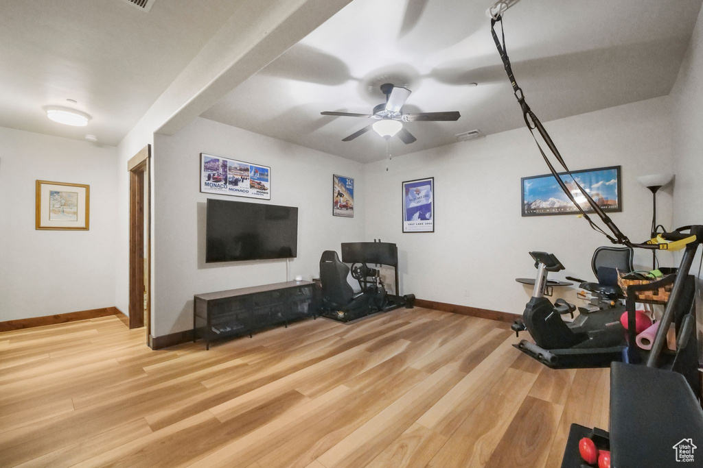 Interior space featuring baseboards, a ceiling fan, and wood finished floors
