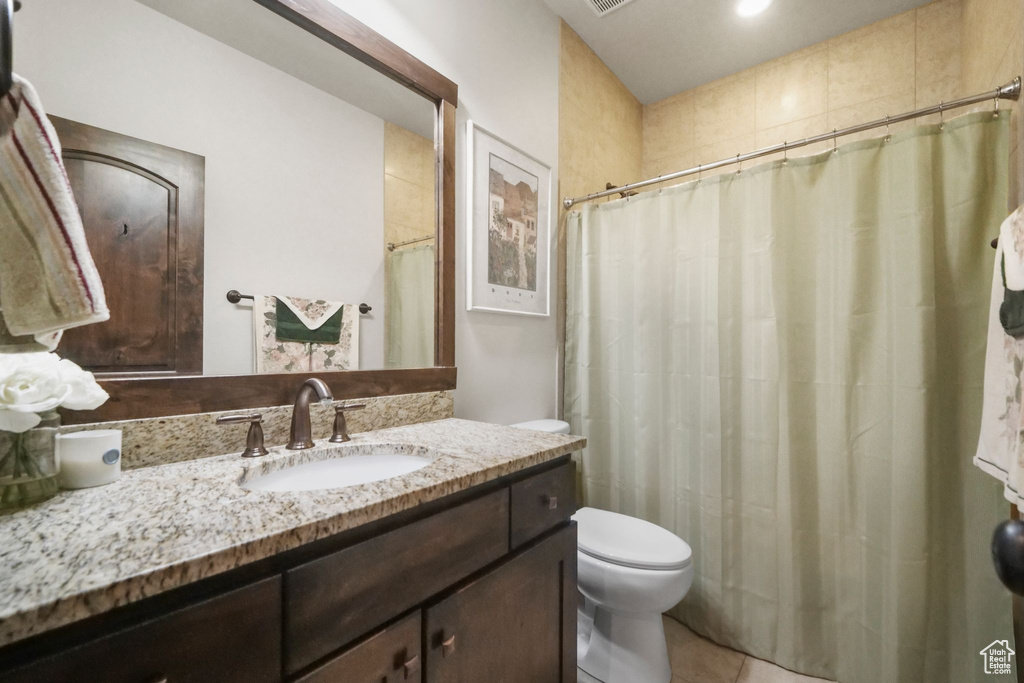 Bathroom featuring tile patterned flooring, toilet, and vanity
