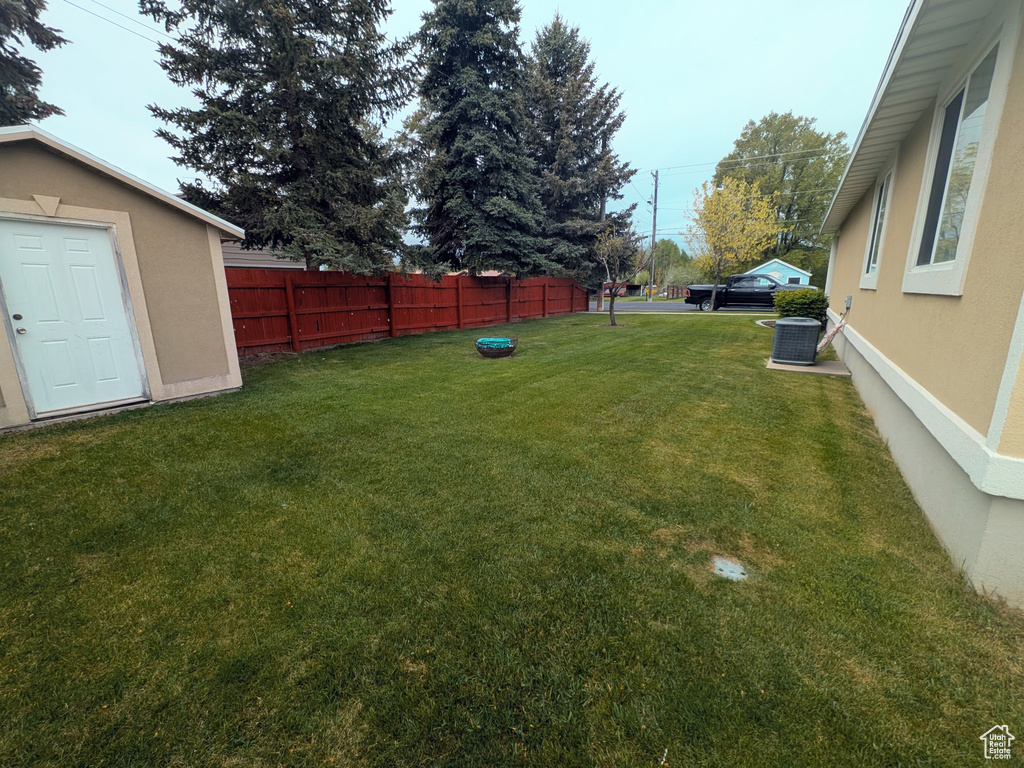View of yard featuring cooling unit and fence