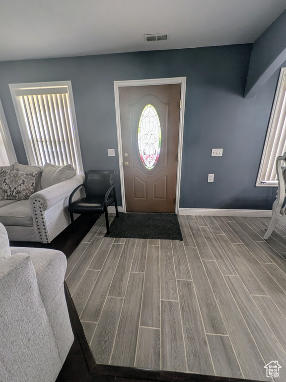 Foyer entrance featuring baseboards, visible vents, and wood finished floors