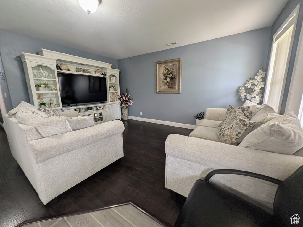 Living room with baseboards, dark wood-style flooring, and visible vents