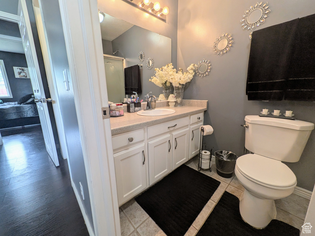 Full bath with toilet, vanity, and a shower stall