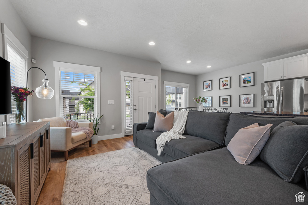 Living room featuring light wood-style floors, baseboards, and recessed lighting