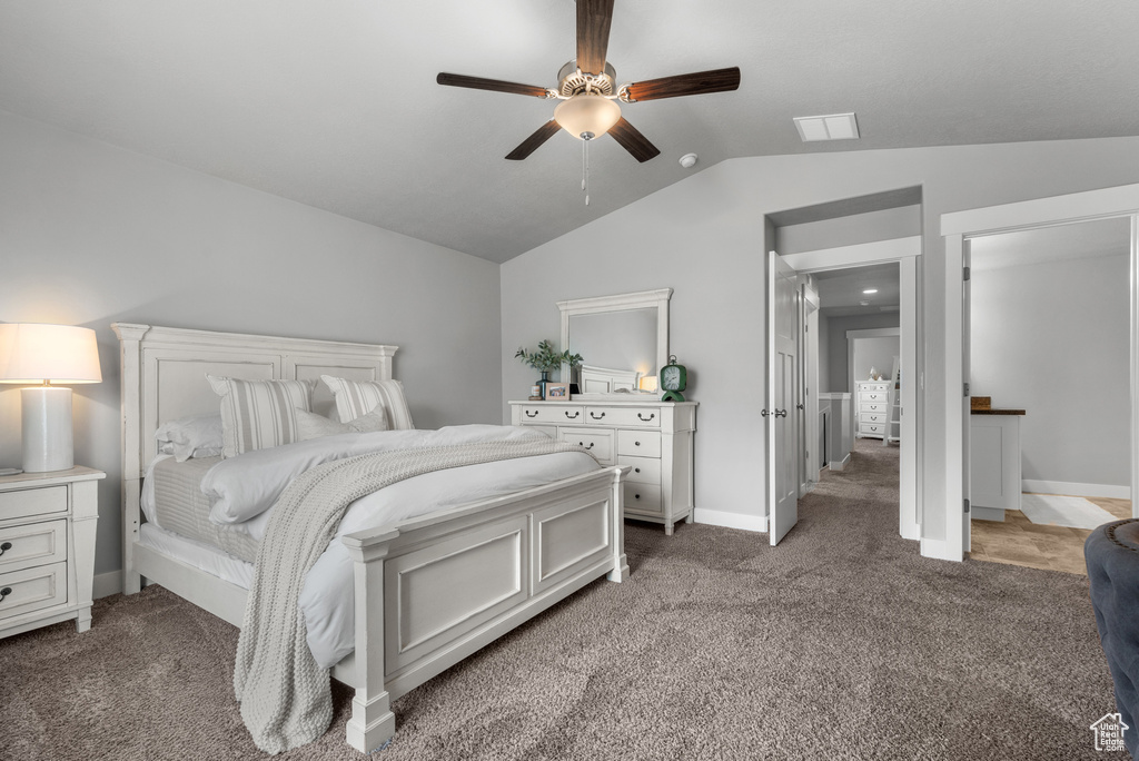 Bedroom with light carpet, lofted ceiling, baseboards, and visible vents