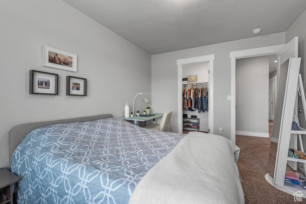 Bedroom with carpet flooring, a closet, baseboards, and a walk in closet