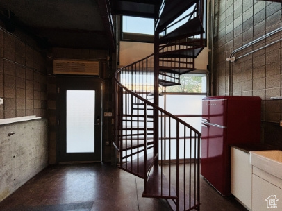 Stairs featuring a wealth of natural light, finished concrete flooring, and a towering ceiling