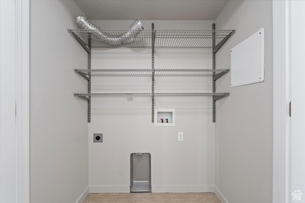 Laundry area with baseboards, hookup for an electric dryer, laundry area, and washer hookup