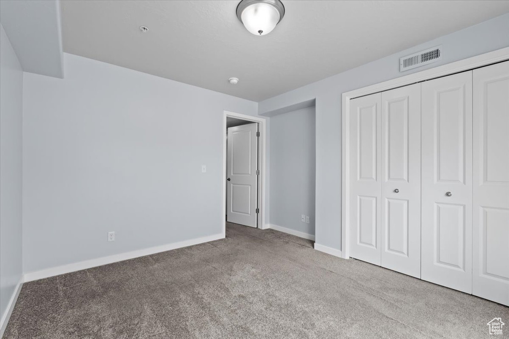 Unfurnished bedroom with a closet, visible vents, baseboards, and carpet floors