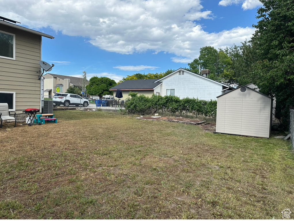View of yard with an outdoor structure and a shed