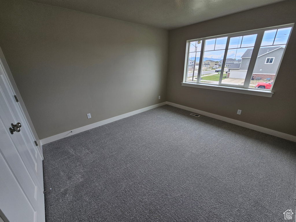 Carpeted empty room with baseboards and visible vents