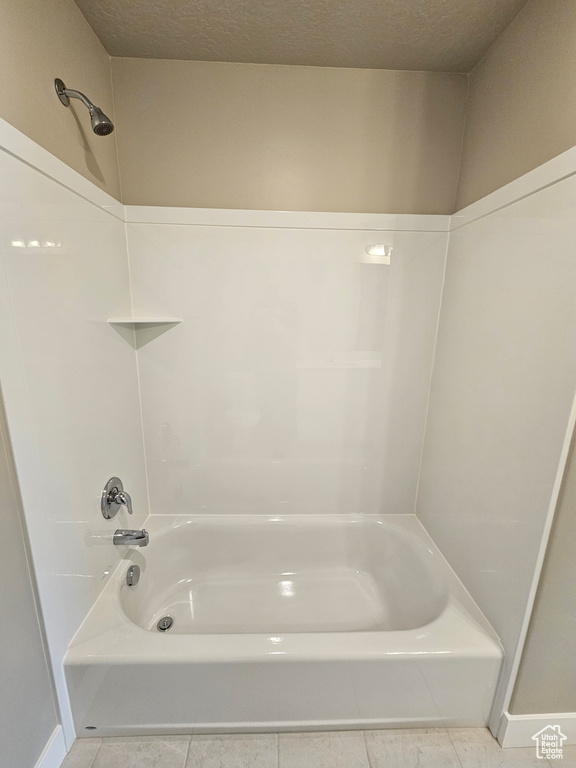Full bath with tile patterned flooring and shower / washtub combination