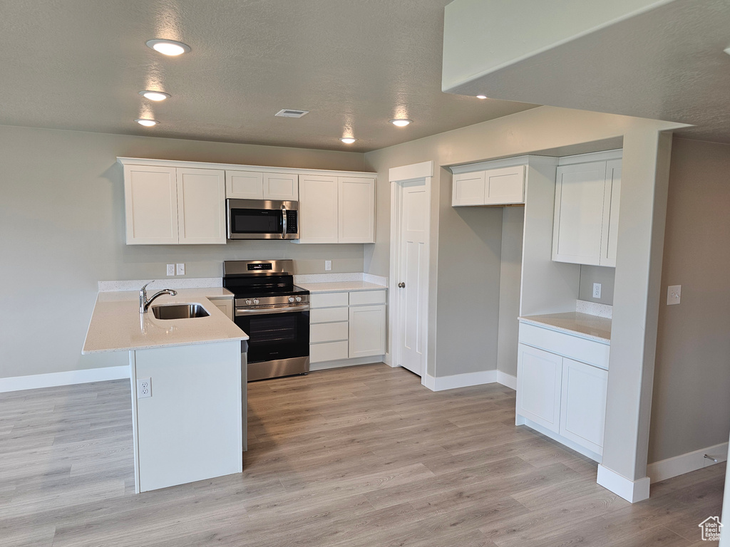 Kitchen with stainless steel appliances, baseboards, and a sink