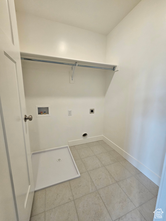 Clothes washing area featuring laundry area, light tile patterned floors, electric dryer hookup, baseboards, and hookup for a washing machine