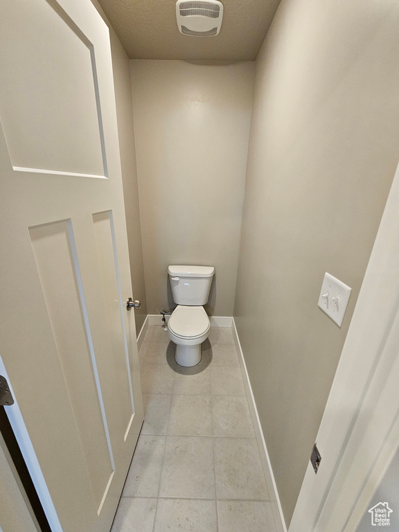 Bathroom featuring toilet, visible vents, baseboards, and tile patterned flooring