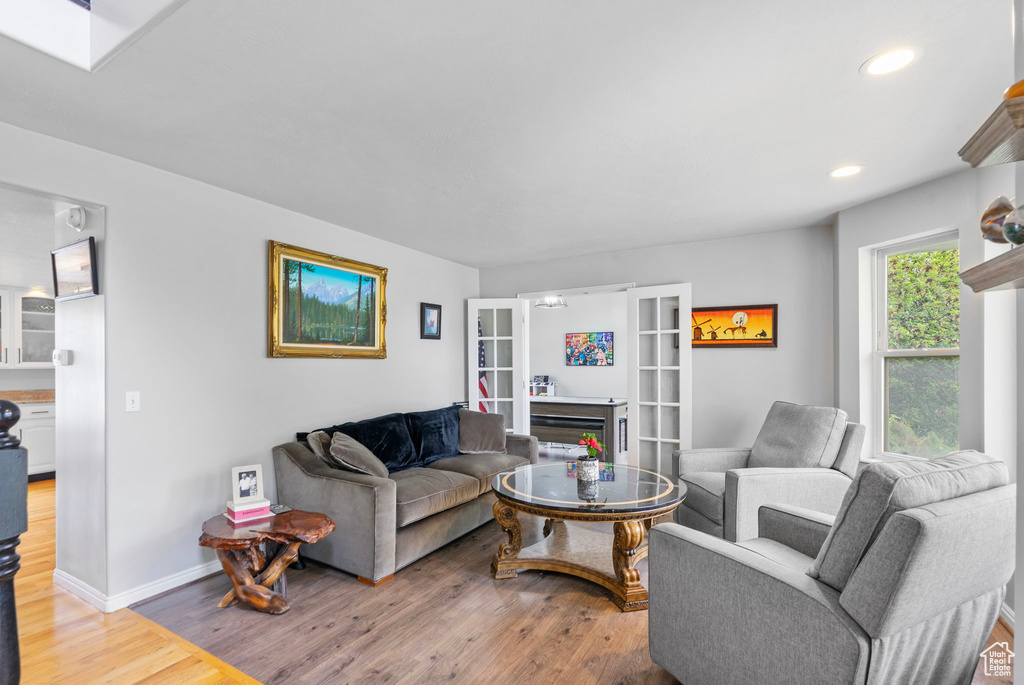 Living area featuring baseboards, light wood-style floors, and recessed lighting
