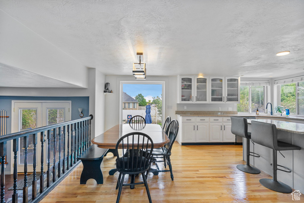 Dining space with a textured ceiling and light wood-style floors