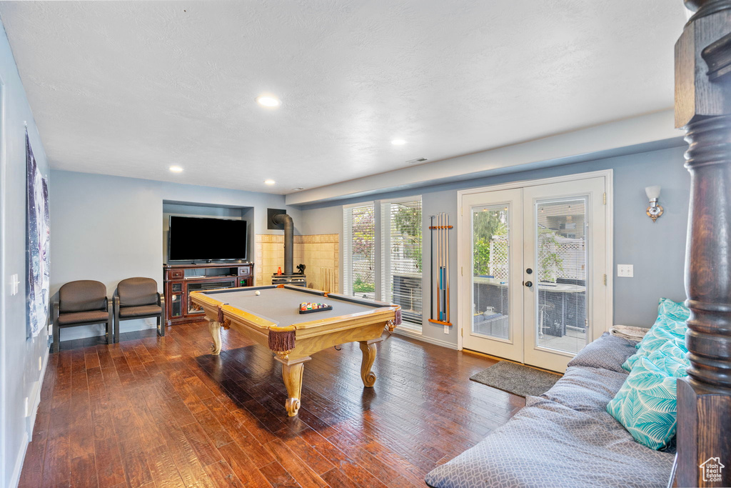 Rec room with pool table, french doors, recessed lighting, wood finished floors, and a wood stove