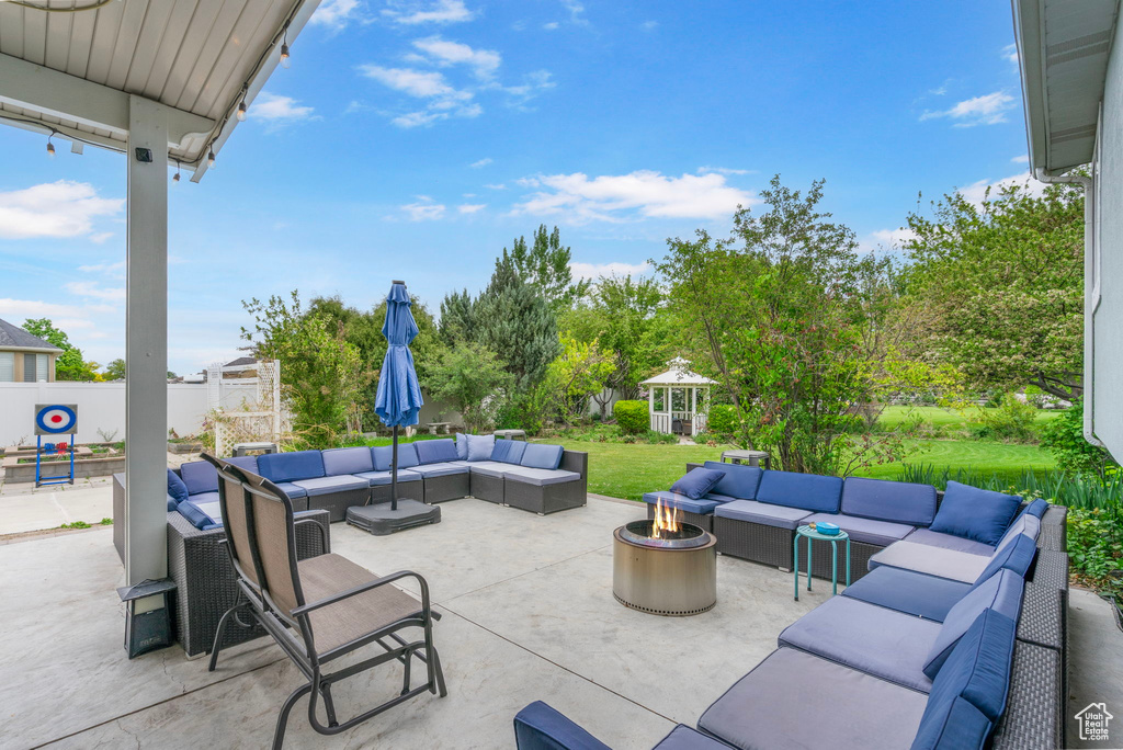 View of patio with an outdoor living space with a fire pit