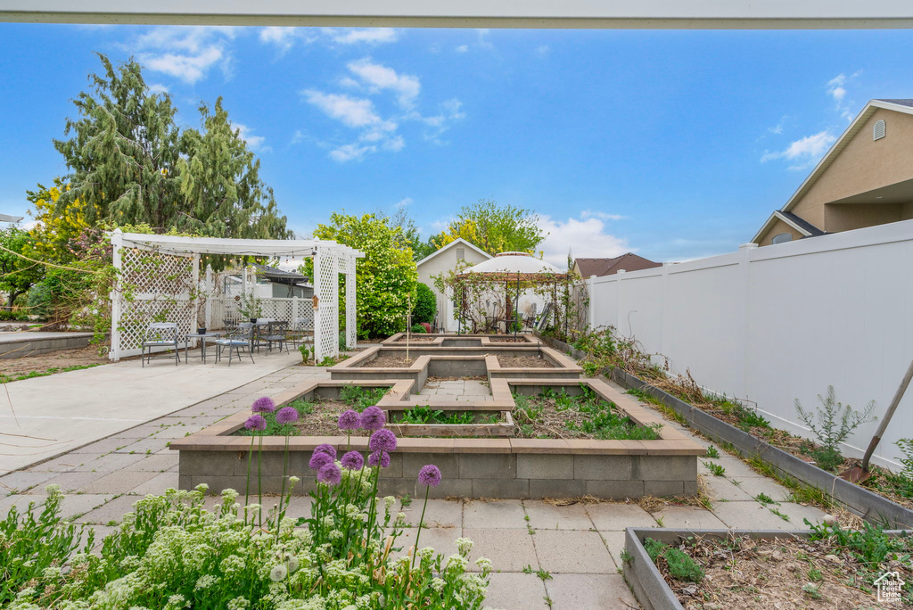 View of yard featuring a patio, a pergola, a garden, a gazebo, and a fenced backyard