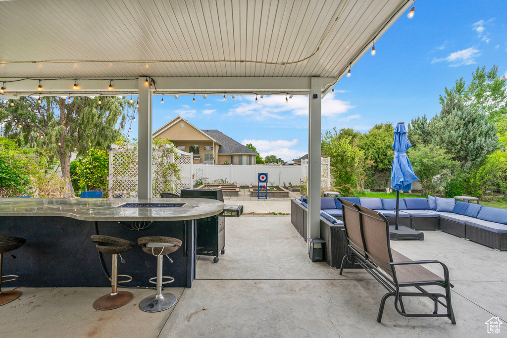 View of patio featuring outdoor dry bar, outdoor lounge area, and fence
