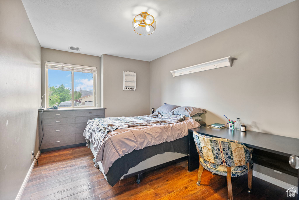 Bedroom featuring visible vents, baseboards, and hardwood / wood-style flooring