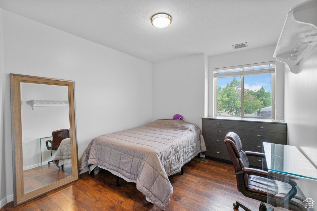 Bedroom with visible vents and hardwood / wood-style flooring