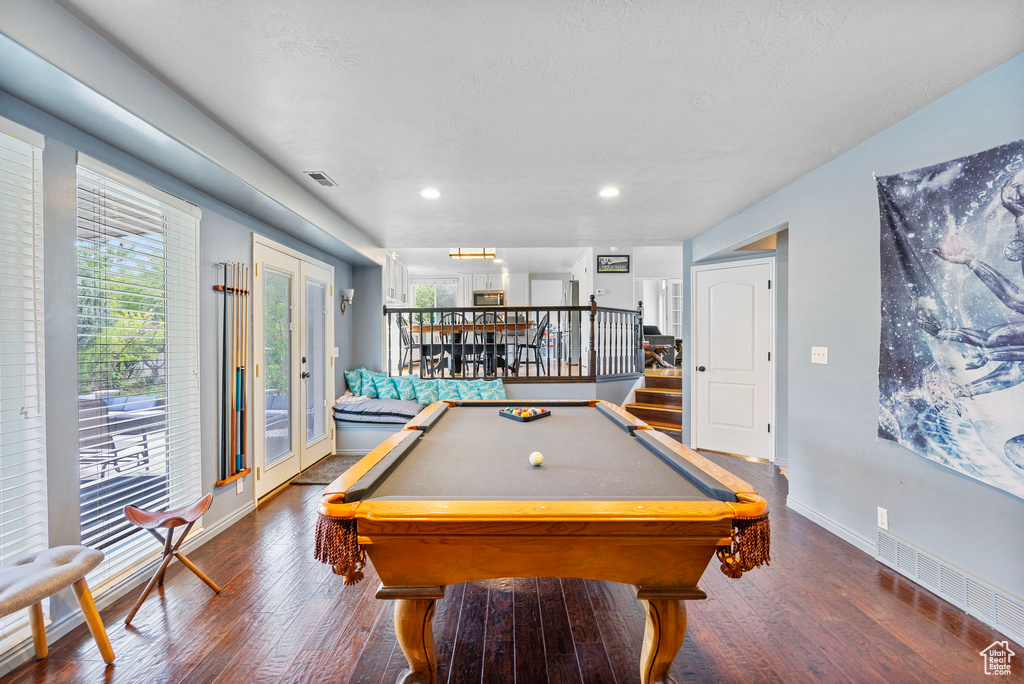 Recreation room with wood finished floors, billiards, baseboards, and visible vents