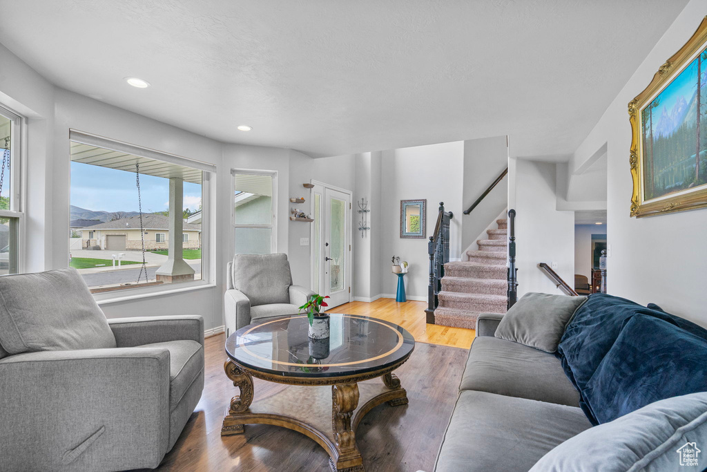 Living area with baseboards, stairs, recessed lighting, and wood finished floors