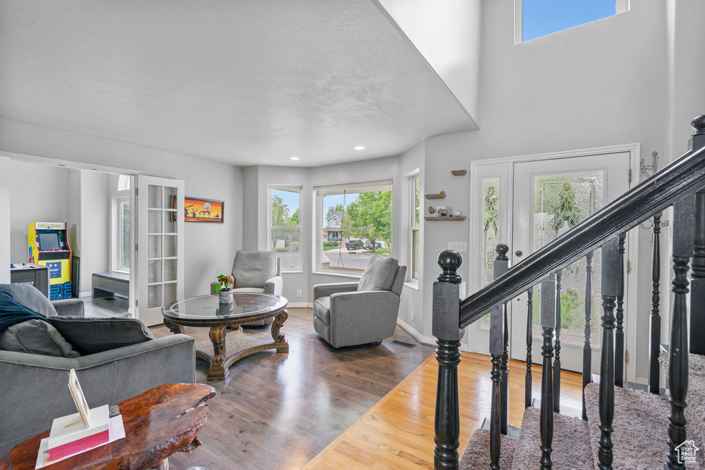 Living area featuring wood finished floors, baseboards, a healthy amount of sunlight, and stairs