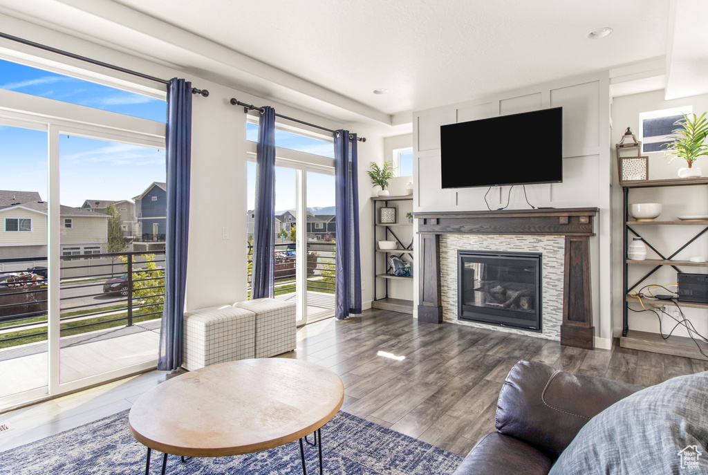 Living room featuring recessed lighting, a glass covered fireplace, and wood finished floors