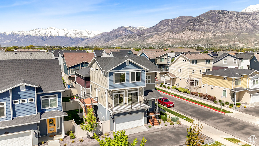 Exterior space with a residential view, a mountain view, and a garage