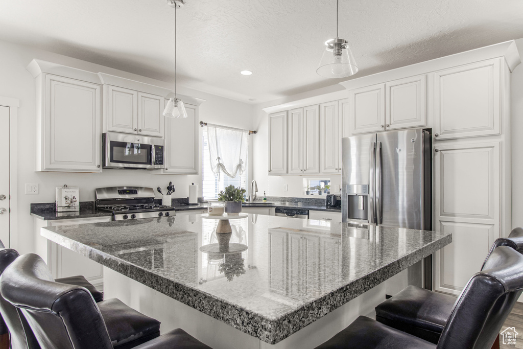 Kitchen with white cabinets, stainless steel appliances, and a breakfast bar