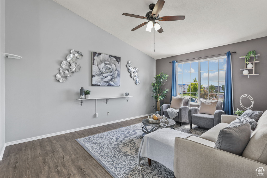 Living room with vaulted ceiling, wood finished floors, baseboards, and ceiling fan