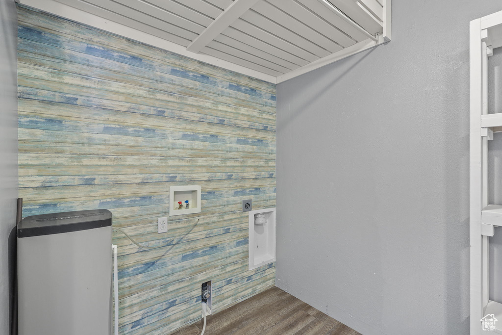 Laundry room featuring wood walls, wood finished floors, laundry area, electric dryer hookup, and hookup for a washing machine