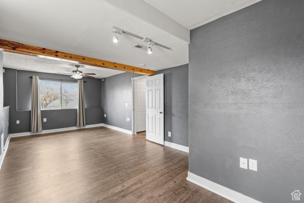Spare room with dark wood finished floors, visible vents, baseboards, and a ceiling fan