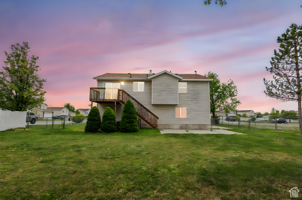 Rear view of property featuring a yard, stairway, and a fenced backyard