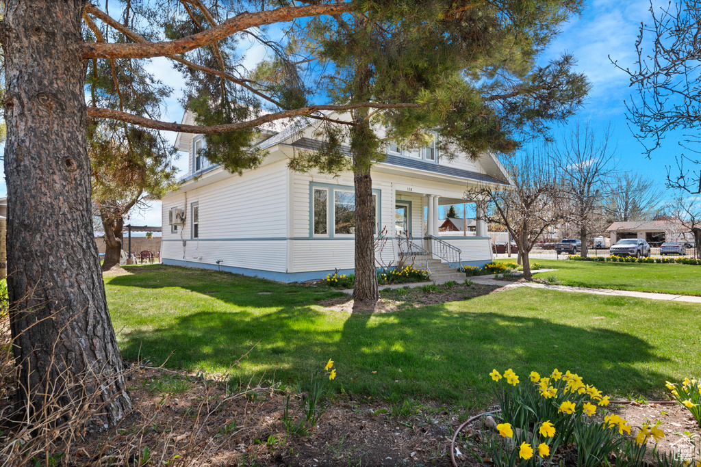 View of home's exterior featuring a yard and covered porch