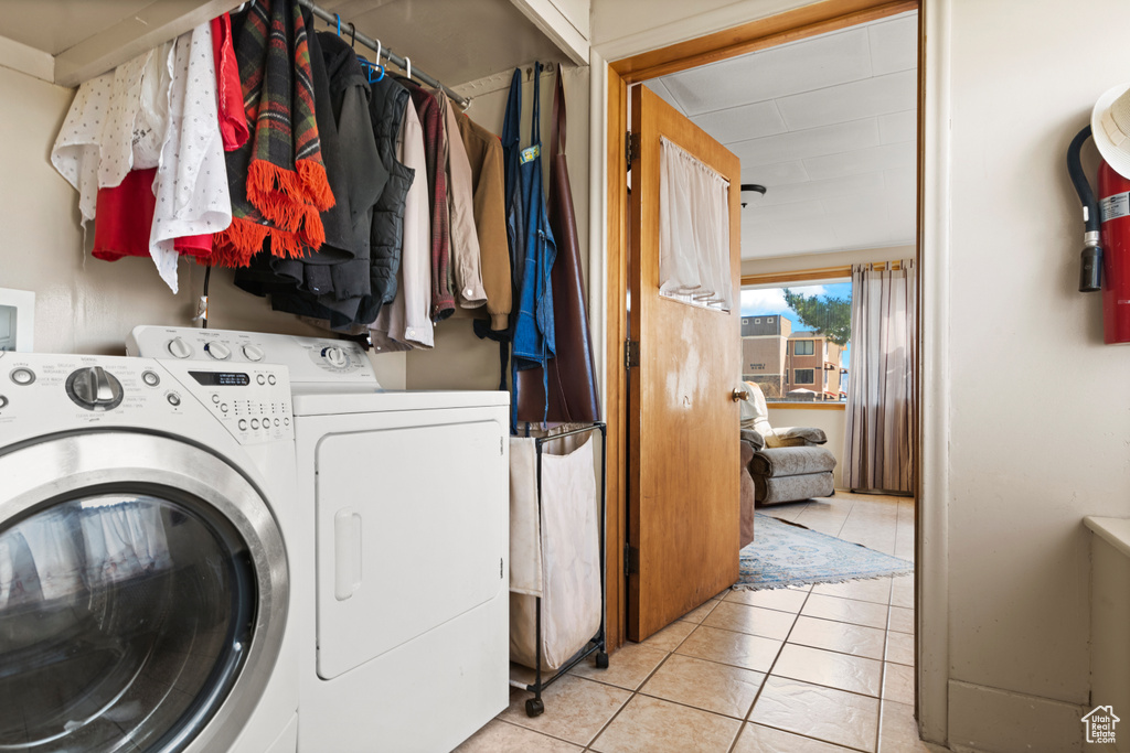 Laundry area featuring washing machine and clothes dryer, laundry area, and light tile patterned floors