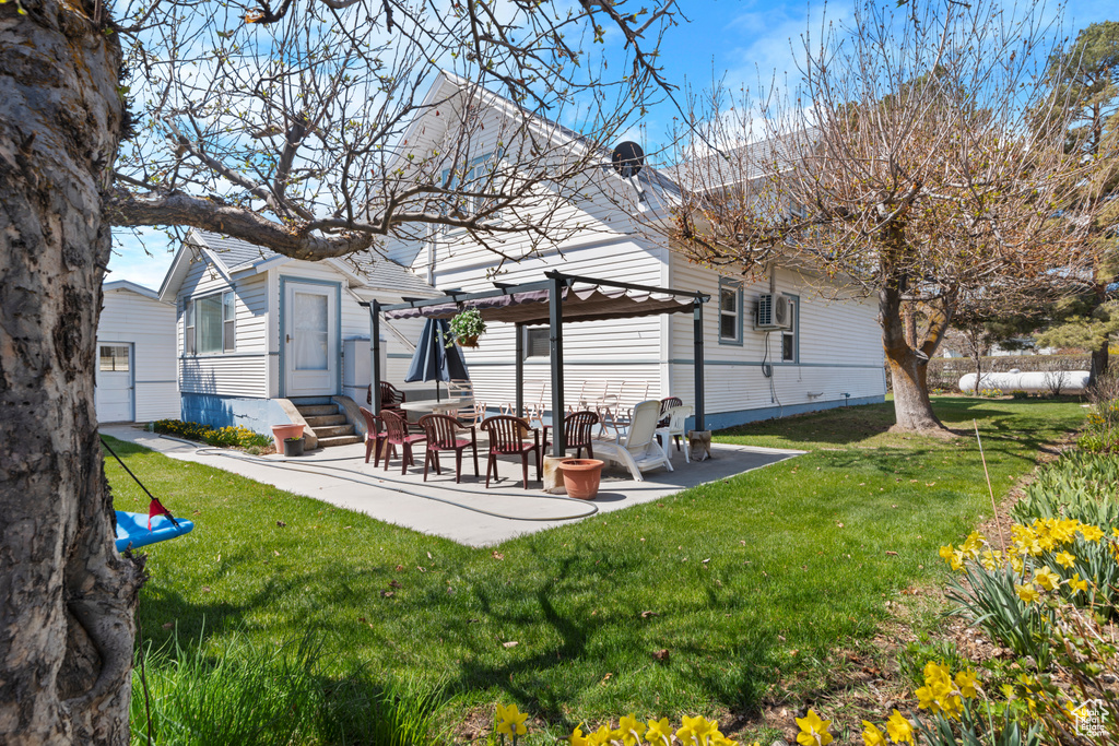 Rear view of house with a yard, a pergola, entry steps, and a patio