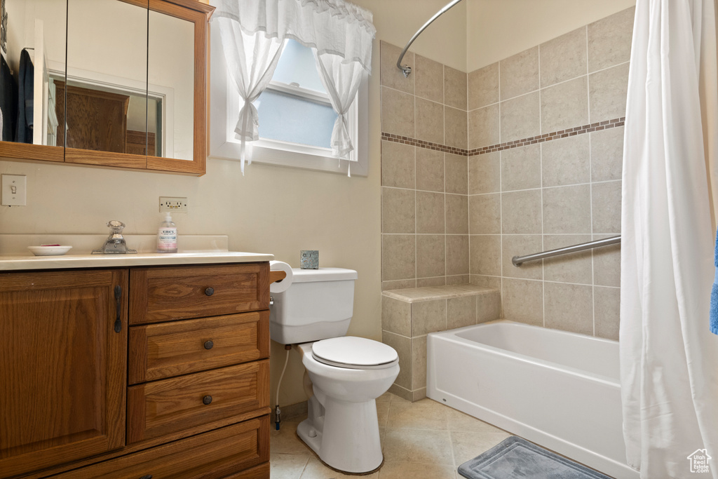 Bathroom with shower / bath combo with shower curtain, toilet, tile patterned flooring, and vanity