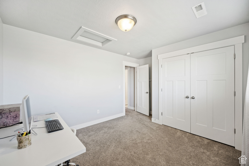 Unfurnished office featuring carpet flooring, attic access, visible vents, and baseboards