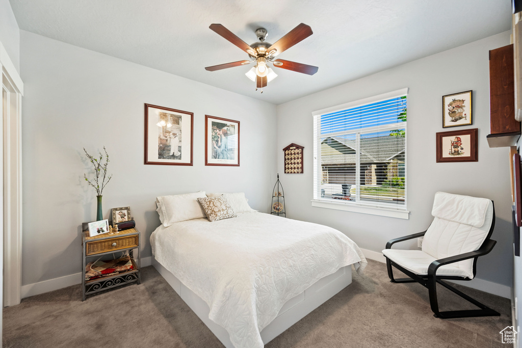 Bedroom with ceiling fan, carpet floors, and baseboards